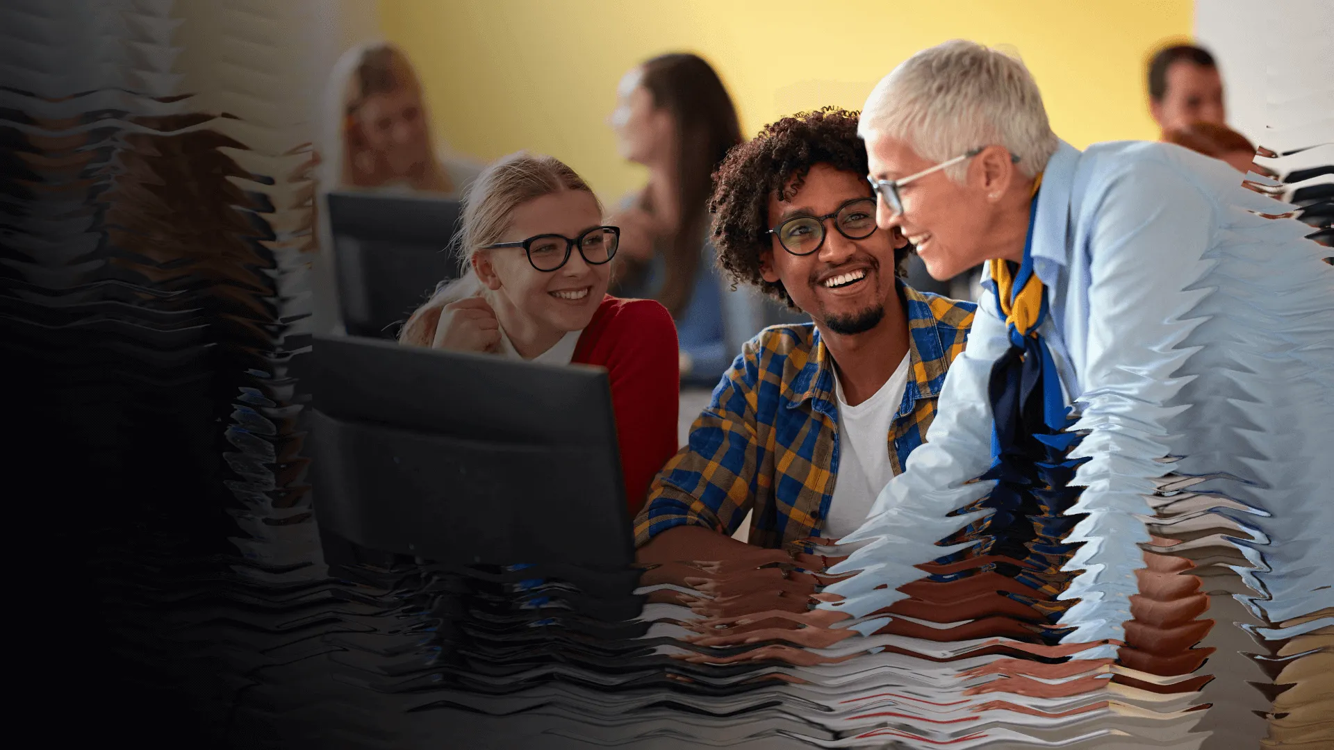 A trainer meets with some new employees at their work station, smiling while they go over a topic