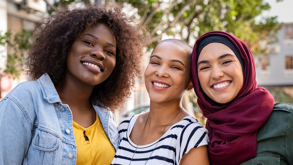 Three ladies smiling towards the camera