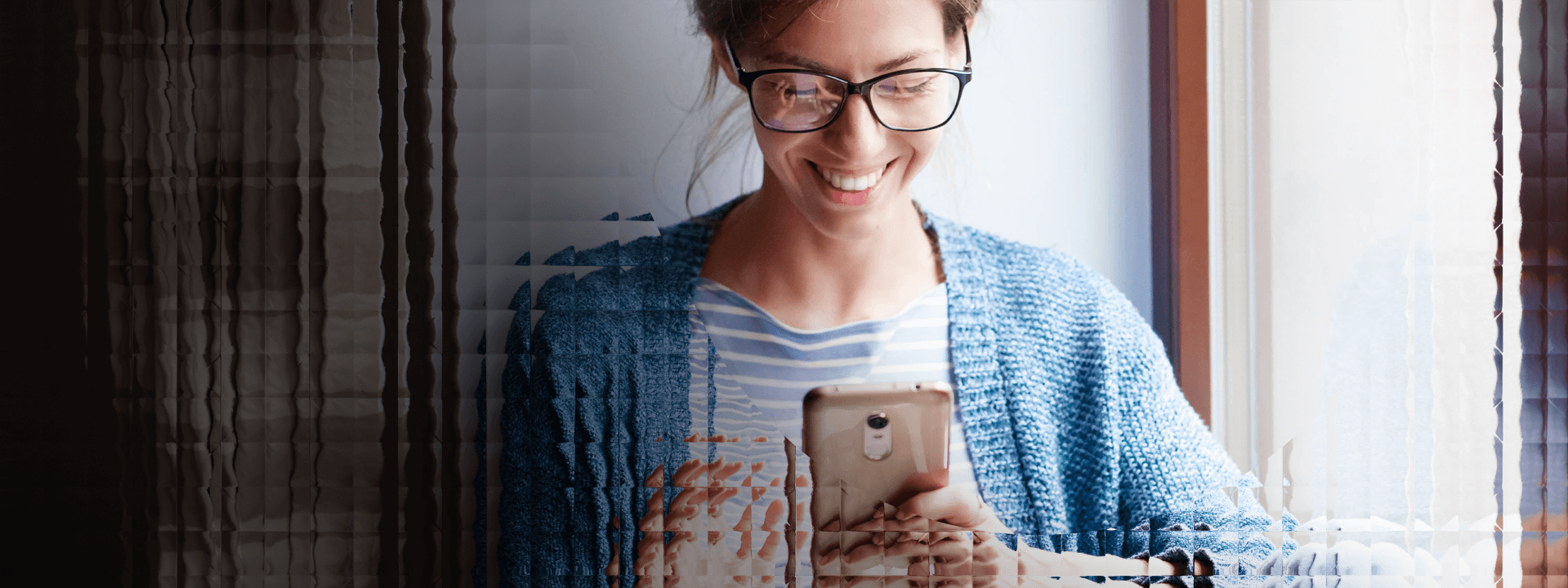 A woman smiles while she does some online banking on her mobile device