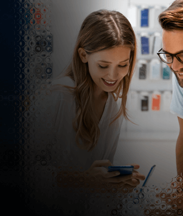 Two people review the features of a mobile device