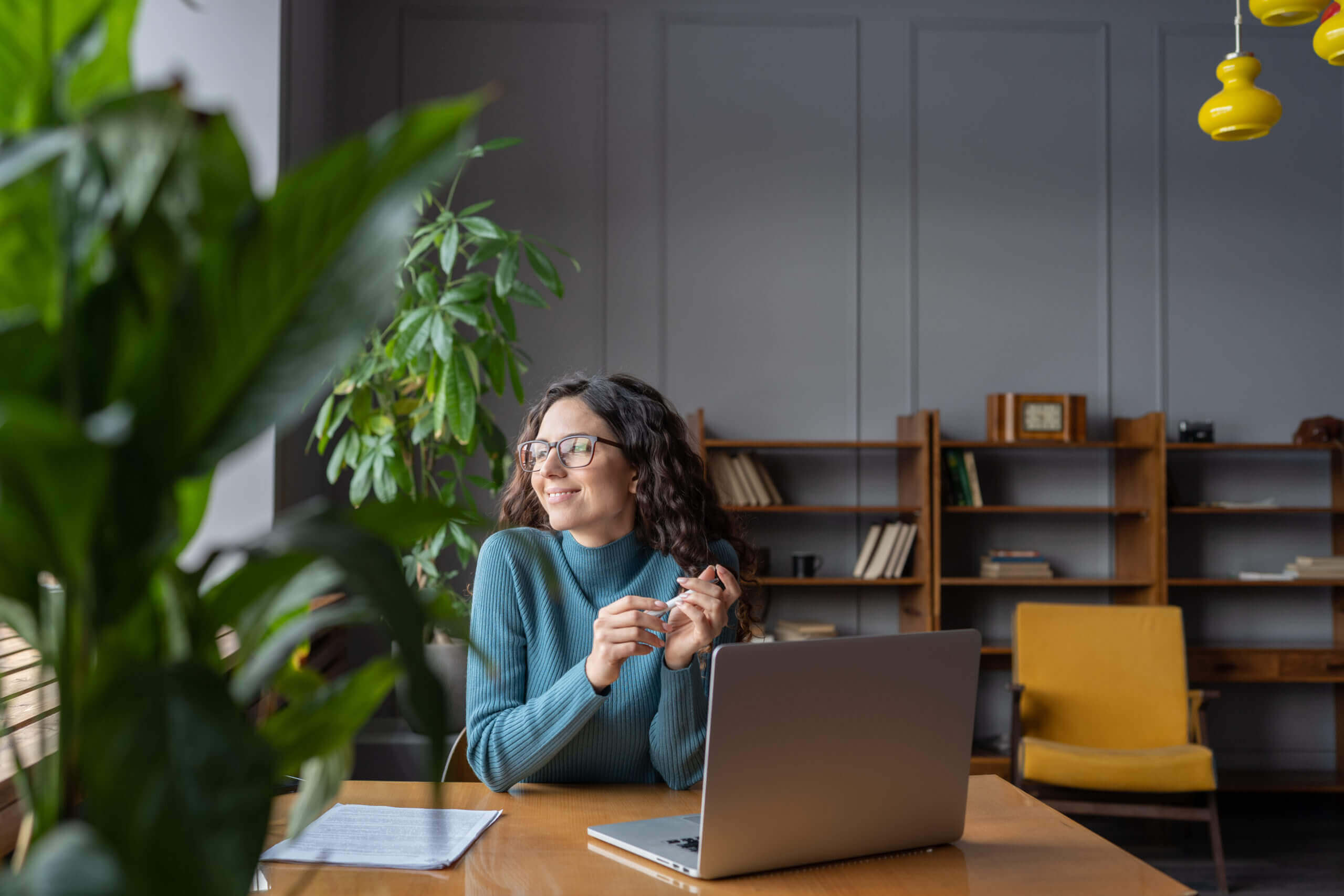 A smiling woman looking out the window while working