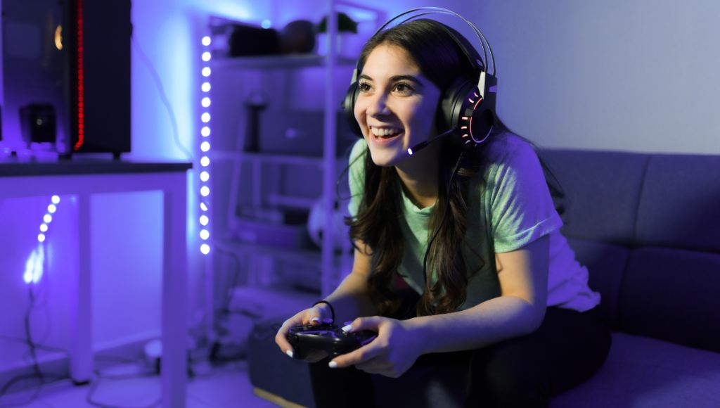 Smiling gamer girl with a headset and a controller