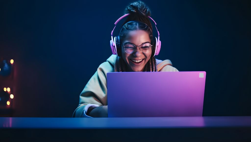 Happy girl with headphones looking at her laptop