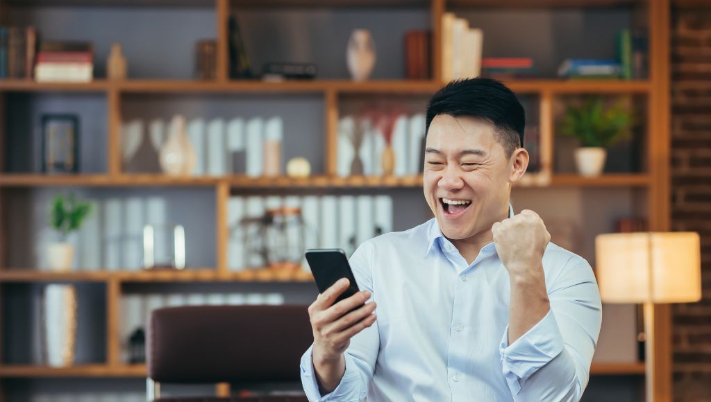 Excited man looking at his phone