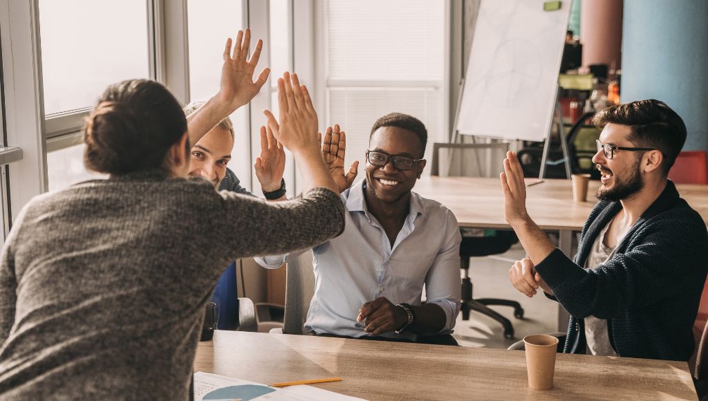 Image of a team high-fiving each other