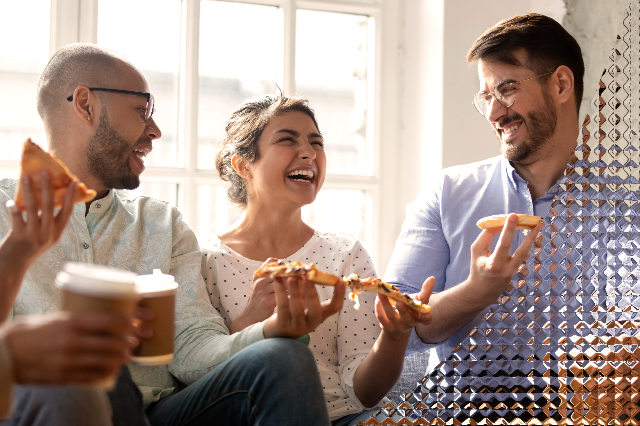 Three happy friends laughing with food on their hands.