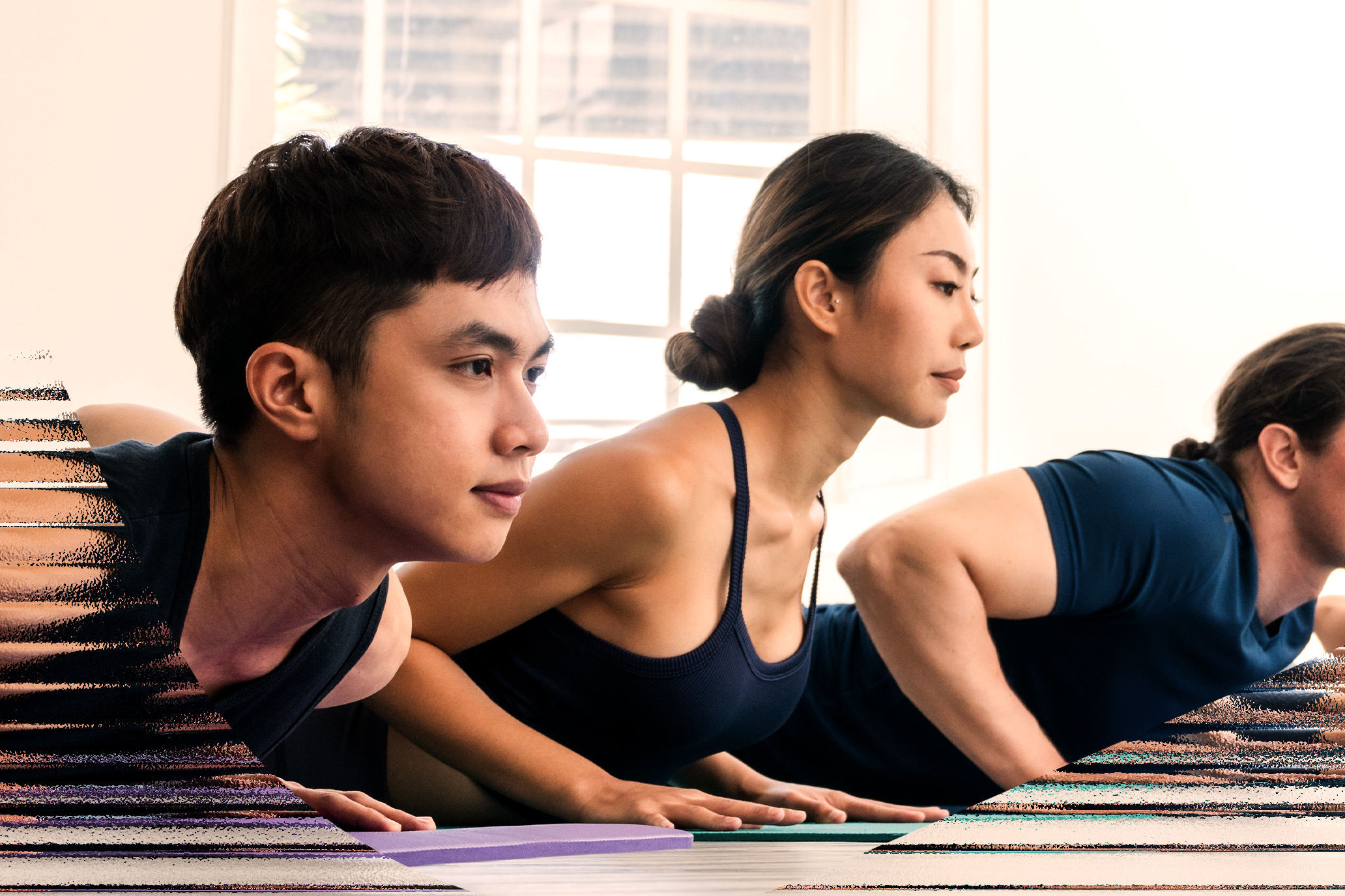Group of three people doing a yoga pose.