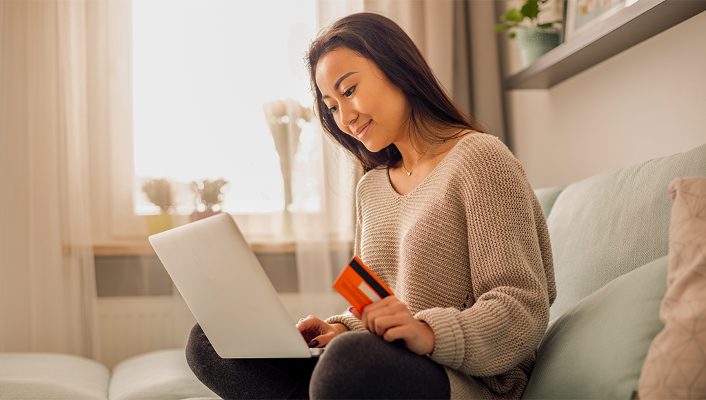 Photo for a woman holding her credit card and a laptop